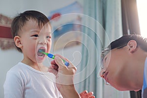 Dad teaching son teeth brushing, Cute little  Asian 2 - 3 years old toddler boy child learn to brushing teeth in the morning in