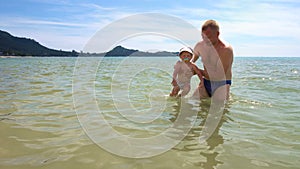 Dad Teaching Toddler to Swim in Sea. Father`s Care Concept