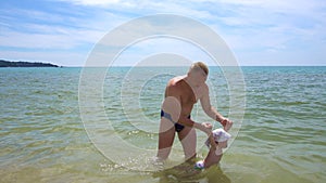 Dad teaching toddler to swim in sea. Father`s care concept