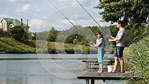 Dad and teenage boy angling together on lake