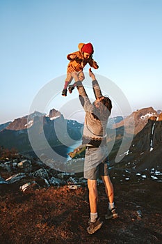 Dad tossing child in the air Family vacations father playing with kid outdoor having fun together hiking in mountains