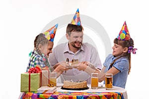 Dad and two daughters fight for the first piece of the holiday cake