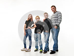 Dad, two sons and daughter in casual clothes in dark colors, full length portrait, white background