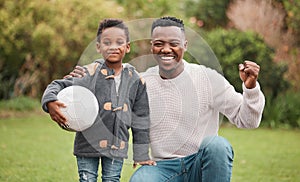 Dad will always cheer him on. Portrait of a father and his son playing with a soccer ball together outdoors.