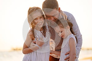 Dad wipes, warms daughters after swimming in sea in dresses. kids in wet clothes