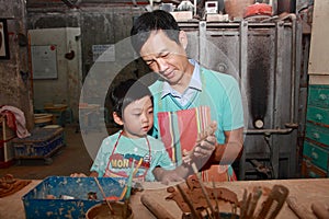 Dad works on pottery with Son,Taibei,Taiwan.