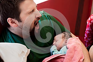 Dad Yawns While Holding His Newborn Son