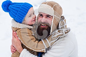 Daddy and boy smiling and hugging. Happy family son hugs his dad on winter holiday.