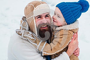 Daddy and boy smiling and hugging. Happy family son hugs his dad on winter holiday.