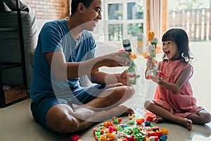 Daddy and child playing with plastic brick