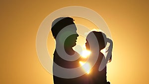 Daddy is circling his beloved healthy daughter in his arms. silhouette of dad and child at sunset. happy father and