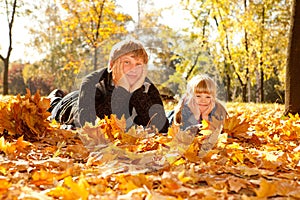 Daddy and daughter on autumn leaves