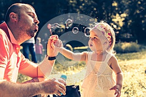 Daddy and daughter blowing bubbles