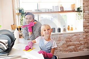 Daddy and daughter enjoying traditional weekend housecleaning