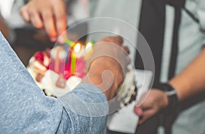 Daddy lighting birthday candles on birthday cake for children brithday party