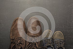 Daddy's boots and baby's shoes, fathers day concept.