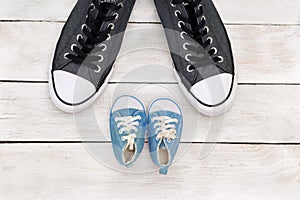 Daddy`s boots and baby`s shoes, fathers day concept.