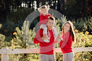 Daddy`s carrying a baby daughter on his shoulders in the autumn park. The concept of family holiday. Father`s, mother`s, baby`