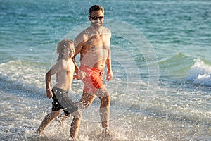 daddy and son running in sea beach. Father son child bonding enjoying summer vacation. Special moments between daddy and
