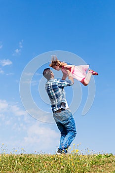 Daddy spinning around his daughter