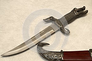 A dagger with a rounded end, sharpened on one side