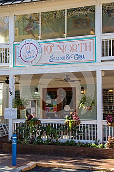 Hanging plants, a cozy porch, and colorful signage at a beach-themed restaurant in Dahlonega, Georgia