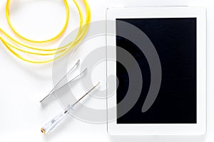 Daignostic of gadgets. Tablet computer, wires and tools on white background top view mockup