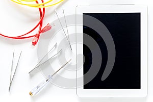 Daignostic of gadgets. Tablet computer, wires and tools on white background top view mockup