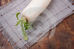 Daikon, east long white radish on brown background. Fresh organic vegan farm vegetables, seasonal harvest, healthy food