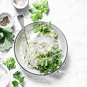 Daikon and kohlrabi cabbage slaw salad on light background
