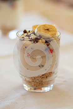 Dairy dessert with fruits, cereals and chocolate in a glass cup