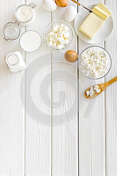 Dairy products from farm with milk, eggs, cottage, butter, yougurt on white wooden background top view mockup