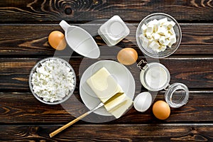 Dairy products from farm with milk, eggs, cottage, butter, yougurt on wooden background top view