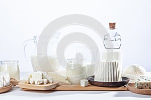 Dairy products in glass recipients and wooden dishes on  white background