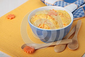 Dairy semolina with carrots in blue ceramic bowl