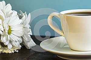 Daisies and Cup Of Coffee On The Wooden Table