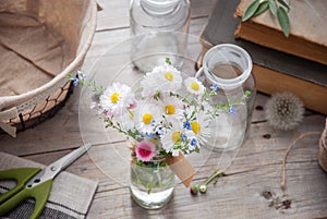 Daisies and forget-me-not flowers bouquet on a gray wooden background