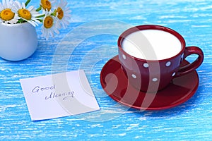 Daisy flowers and cup of milk with good morning note