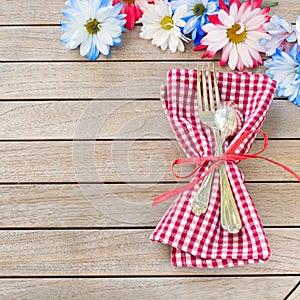 Daisy Flowers in Red White and Blue with Silverware and Napkin Laying on side of Rustic Board Table with room or space for your wo