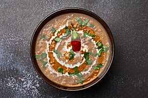 Dal Makhani at dark background. Dal Makhani - traditional indian cuisine puree dish with urad beans, red beans, butter, spices and photo