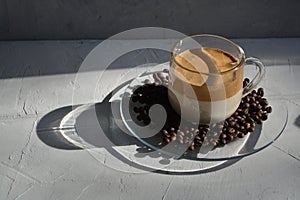 Dalgon coffee on a plate with coffee beans. It`s a hard light. Horizontal image