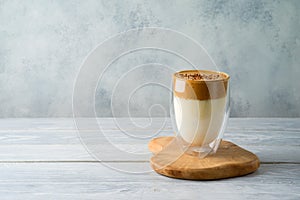 Dalgona coffee or whipped coffee drink with milk on wooden table