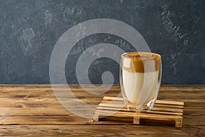 Dalgona coffee or whipped coffee drink with milk on wooden table photo