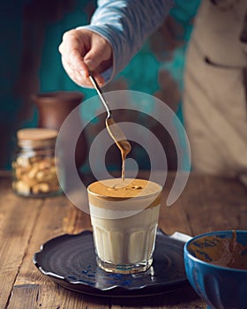 Dalgona coffee or whipped coffee drink with milk on wooden table photo