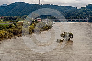 Dam across river with surging water and flooding