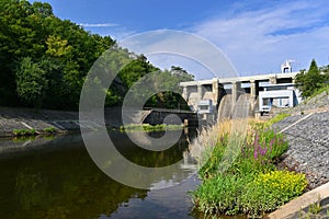 A dam on the Brno Reservoir by the Svratka River with a small power plant. Beautiful sunny summer day in nature