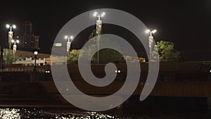 The dam of the Ekaterinburg city with lanterns and the Iset River, Russia. Stock footage. A bridge above the rive at