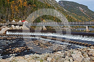 The dam on Malbaie river and pedestrian bridge tlat leads to The Riverain  Path, well-known of hikers