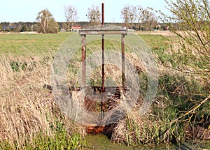 dam-old water damper used to accumulate and stop water flowing from fields and meadows. photo