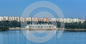 Dam and reservoir. Power, environment. The Serangoon Reservoir East Dam over Sungei Serangoon with Punggol Town on the background